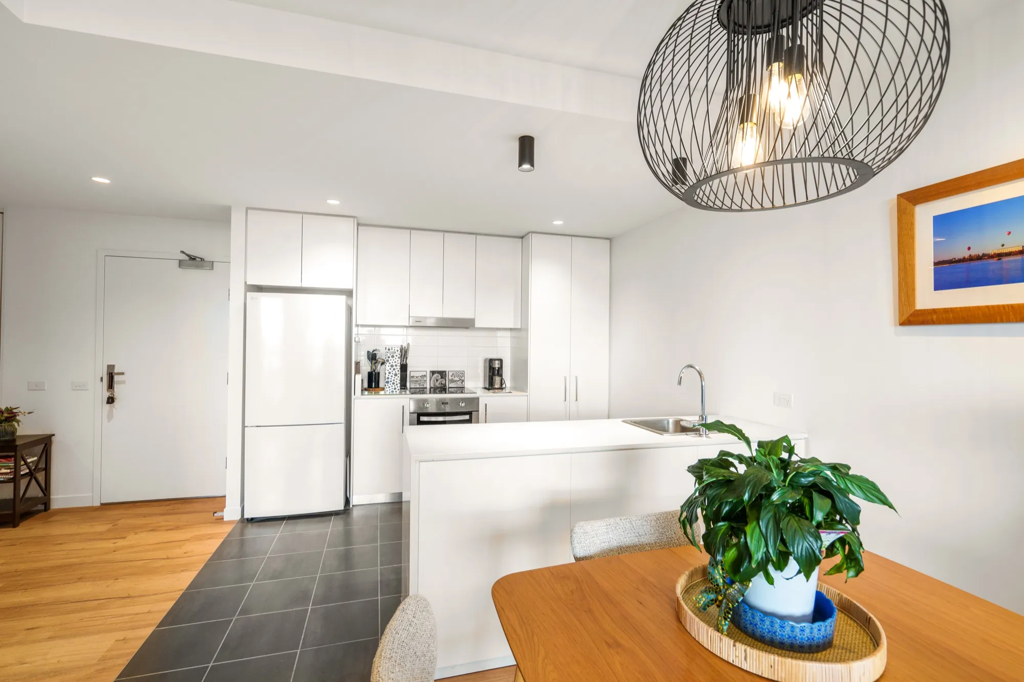 Renovated kitchen and dining in the Bruce apartment with new downlights and a wire pendant light