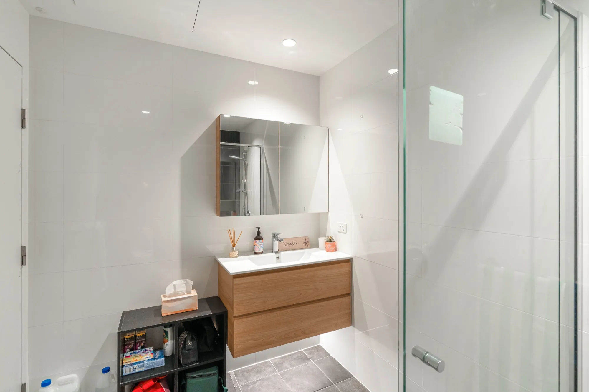 Bruce apartment bathroom with lit mirror cabinet and vanity lighting