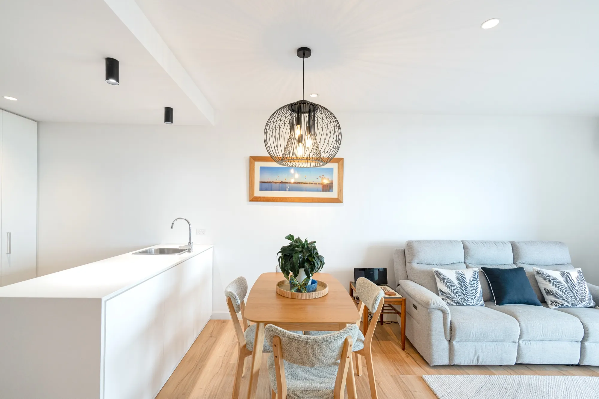 Open plan kitchen, dining and living in the Bruce apartment with layered lighting