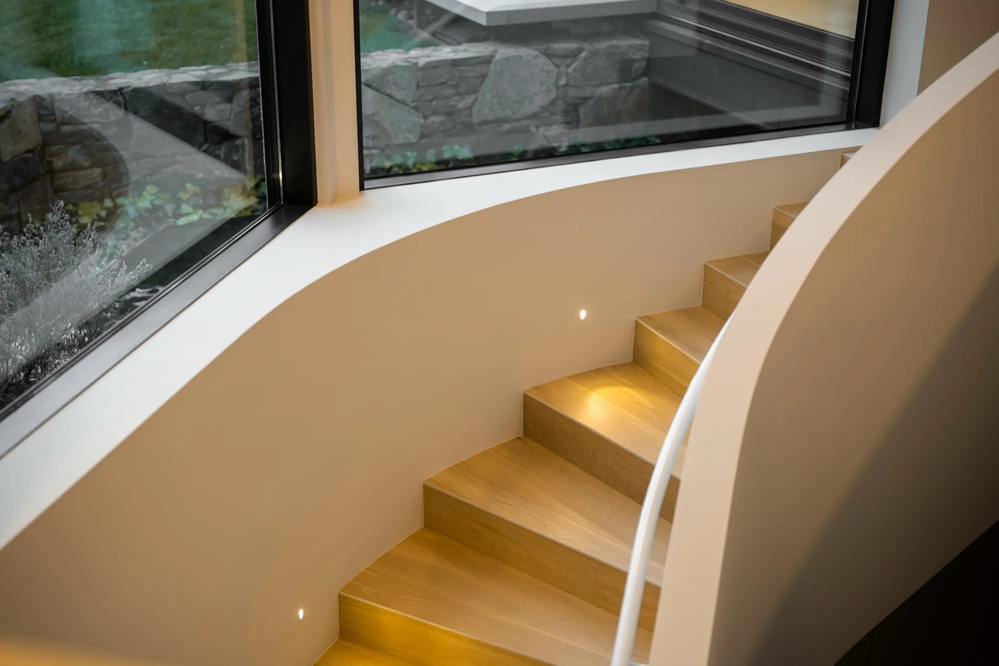 Curved staircase at the Hackett new build seen from above, step lighting on