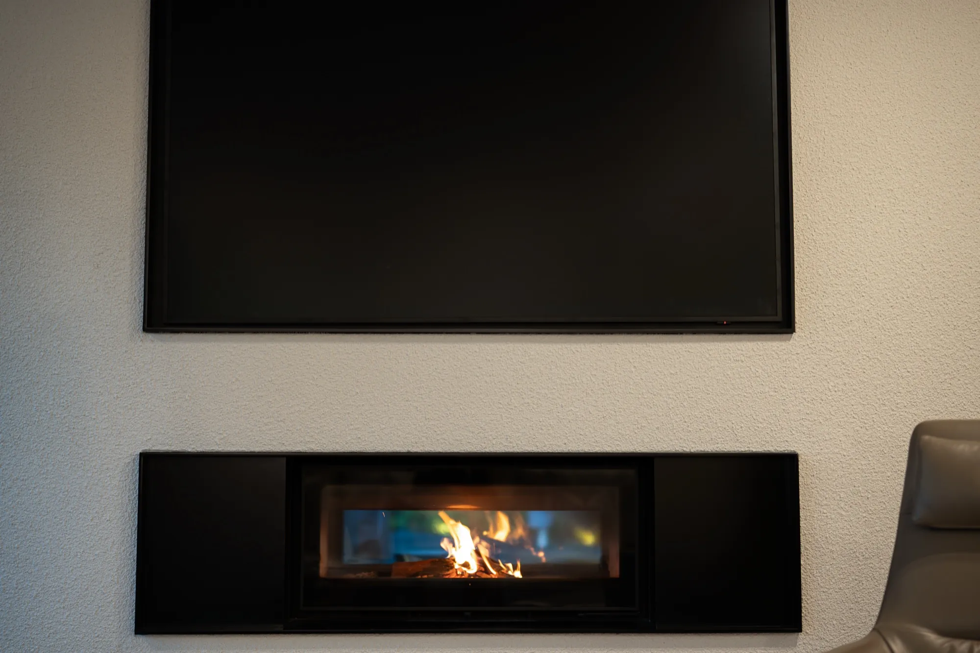 Television mounted above a linear gas fireplace at the Hackett new build