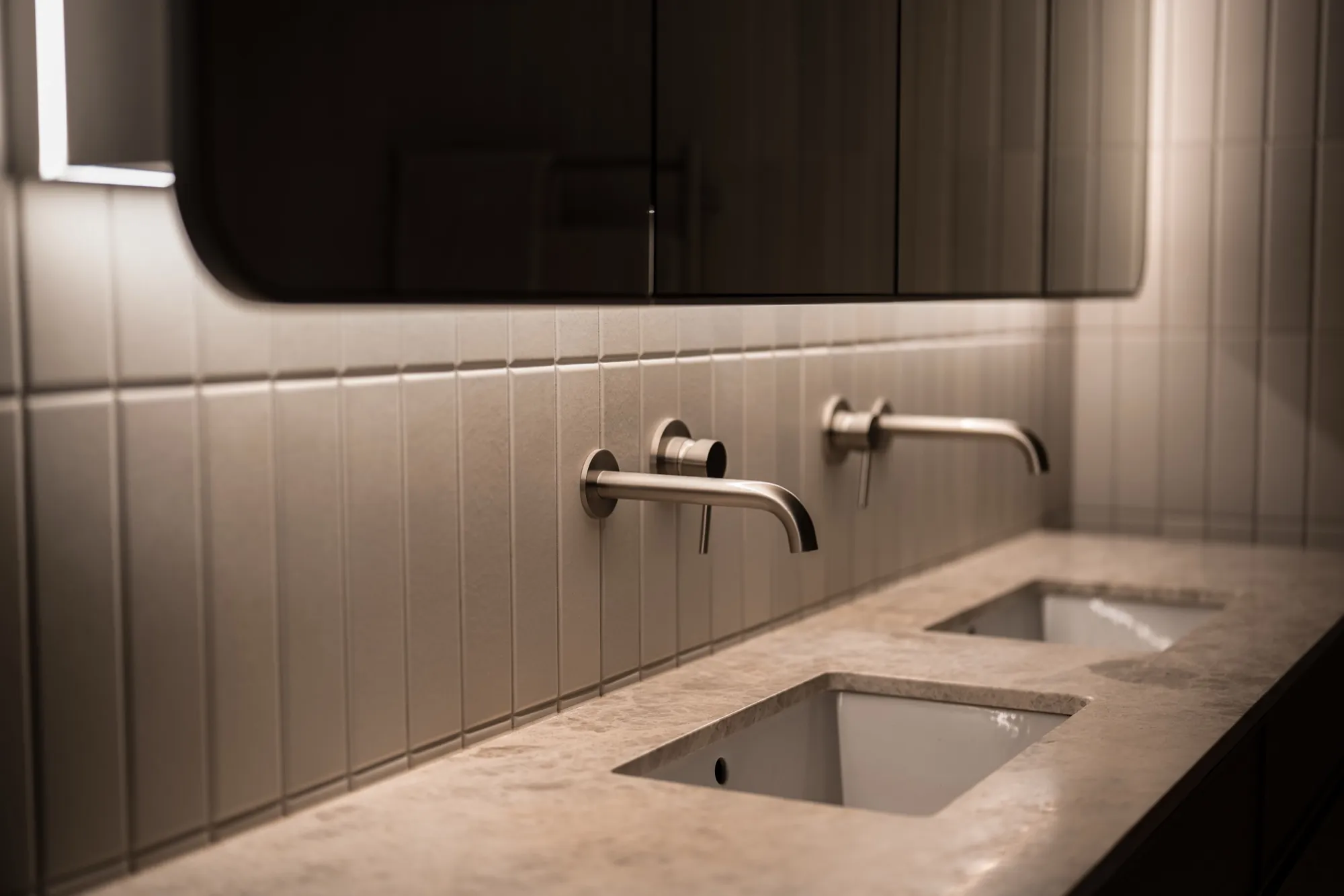 Double vanity bathroom at the Hackett new build with wall-mounted tapware and soft task lighting