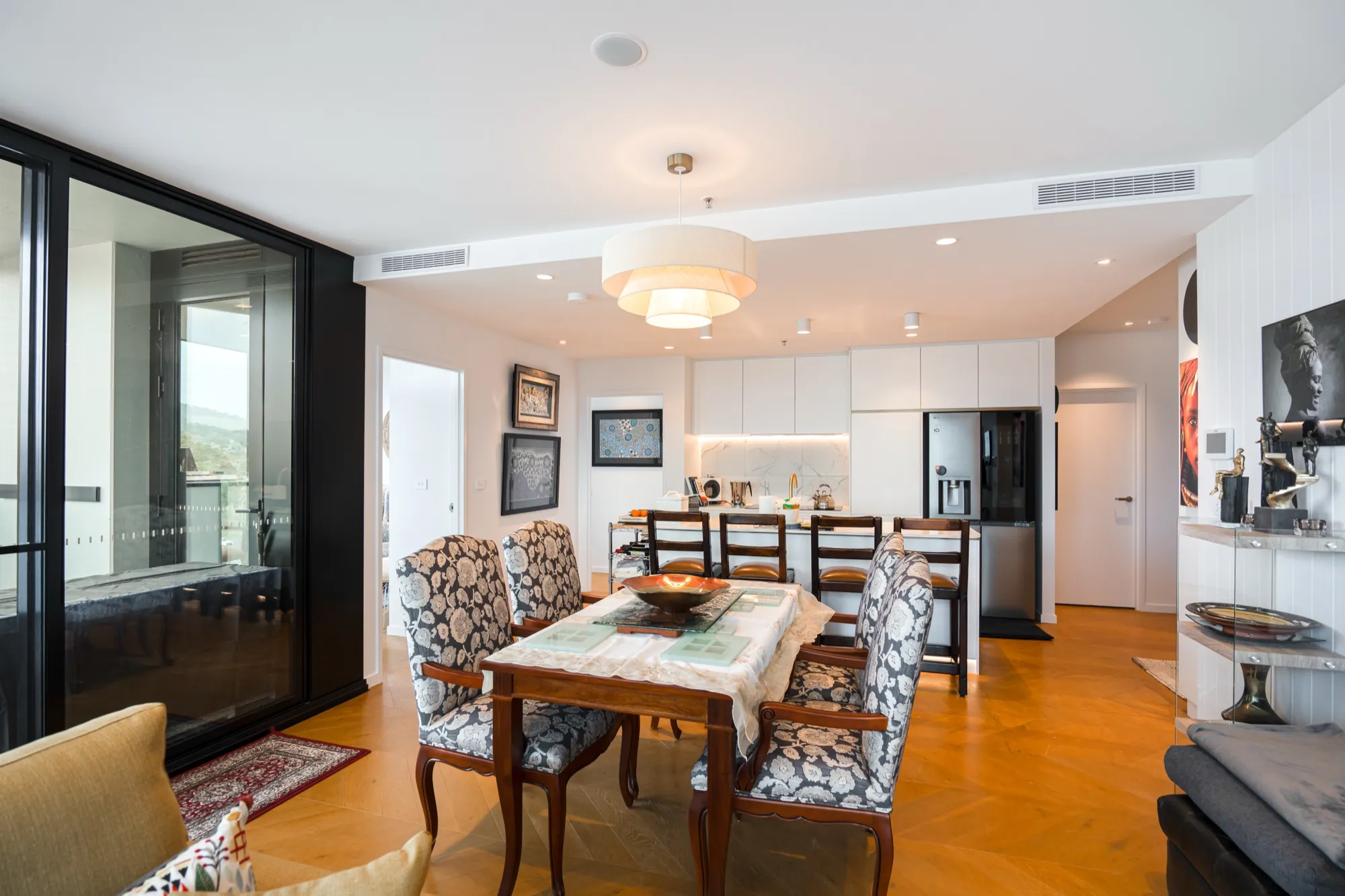 Dining area in the first Phillip apartment with pendant lighting and the kitchen behind