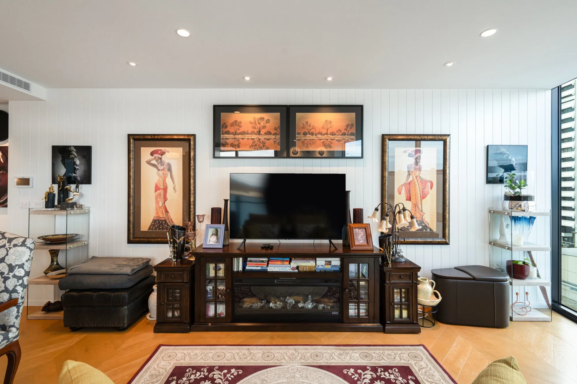 Living room in the first Phillip apartment with warm downlights over the art and television wall