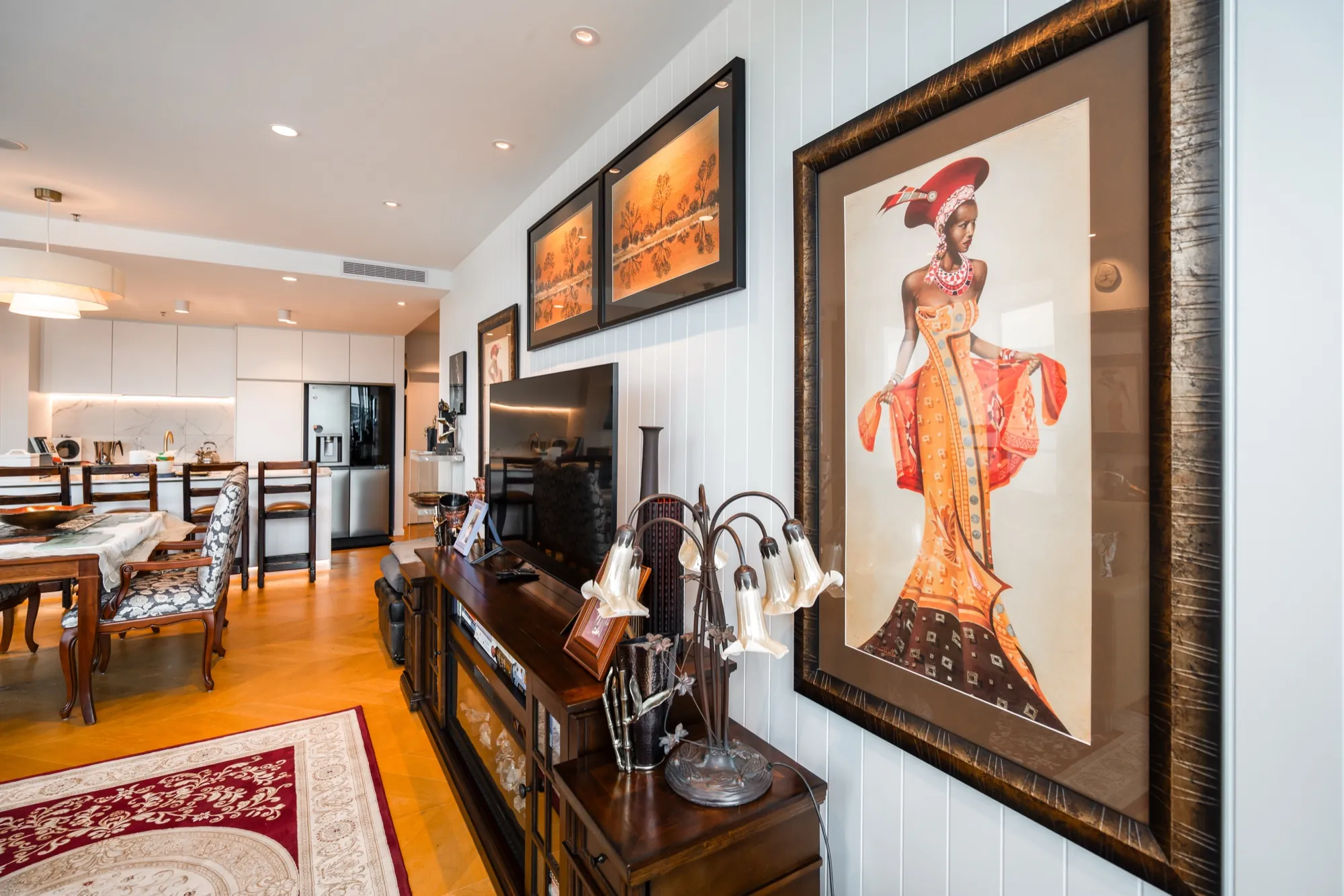 Dining room and art wall in the first Phillip apartment under warm layered lighting