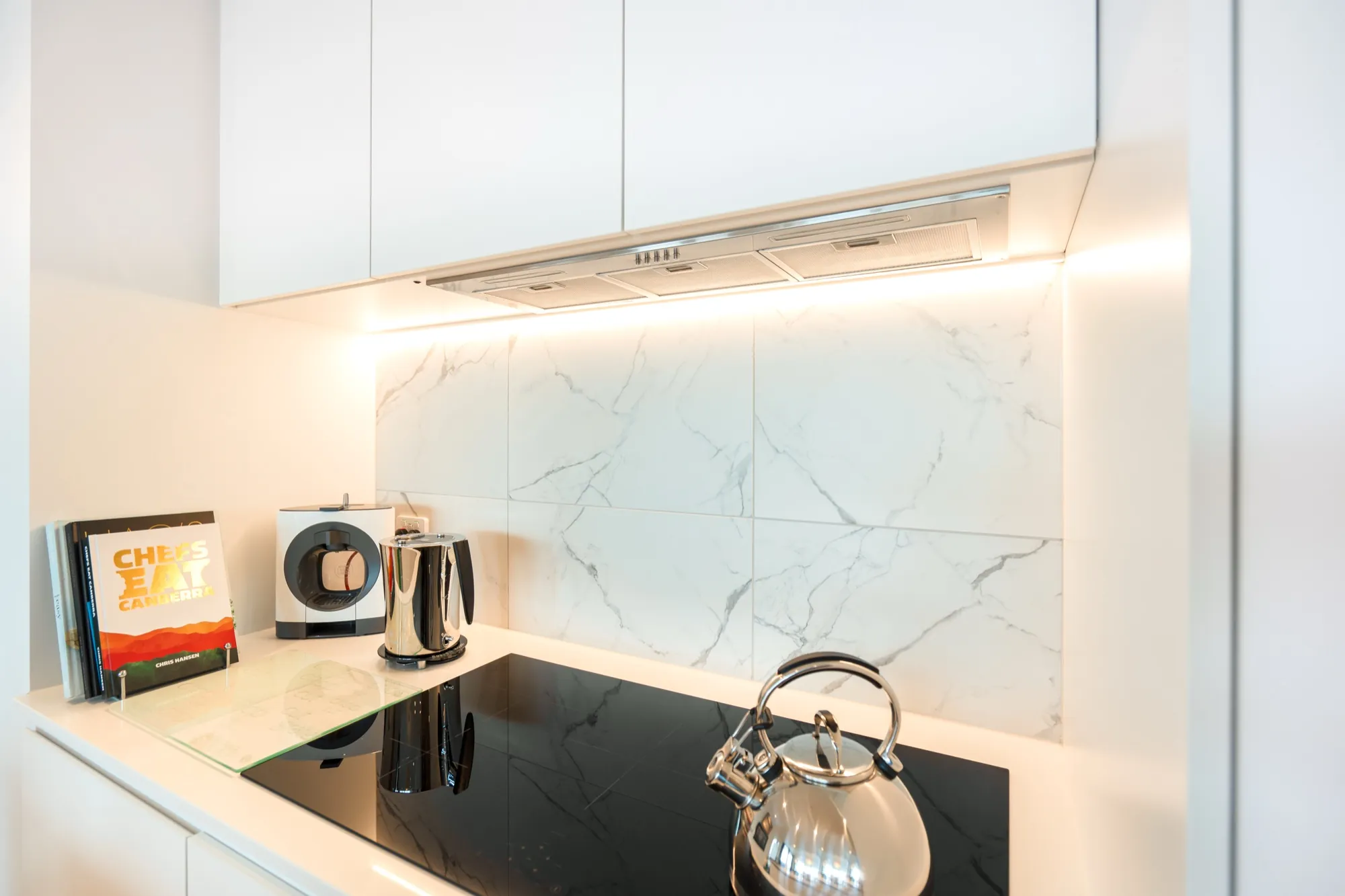 Kitchen splashback in the first Phillip apartment with under-cabinet strip lighting