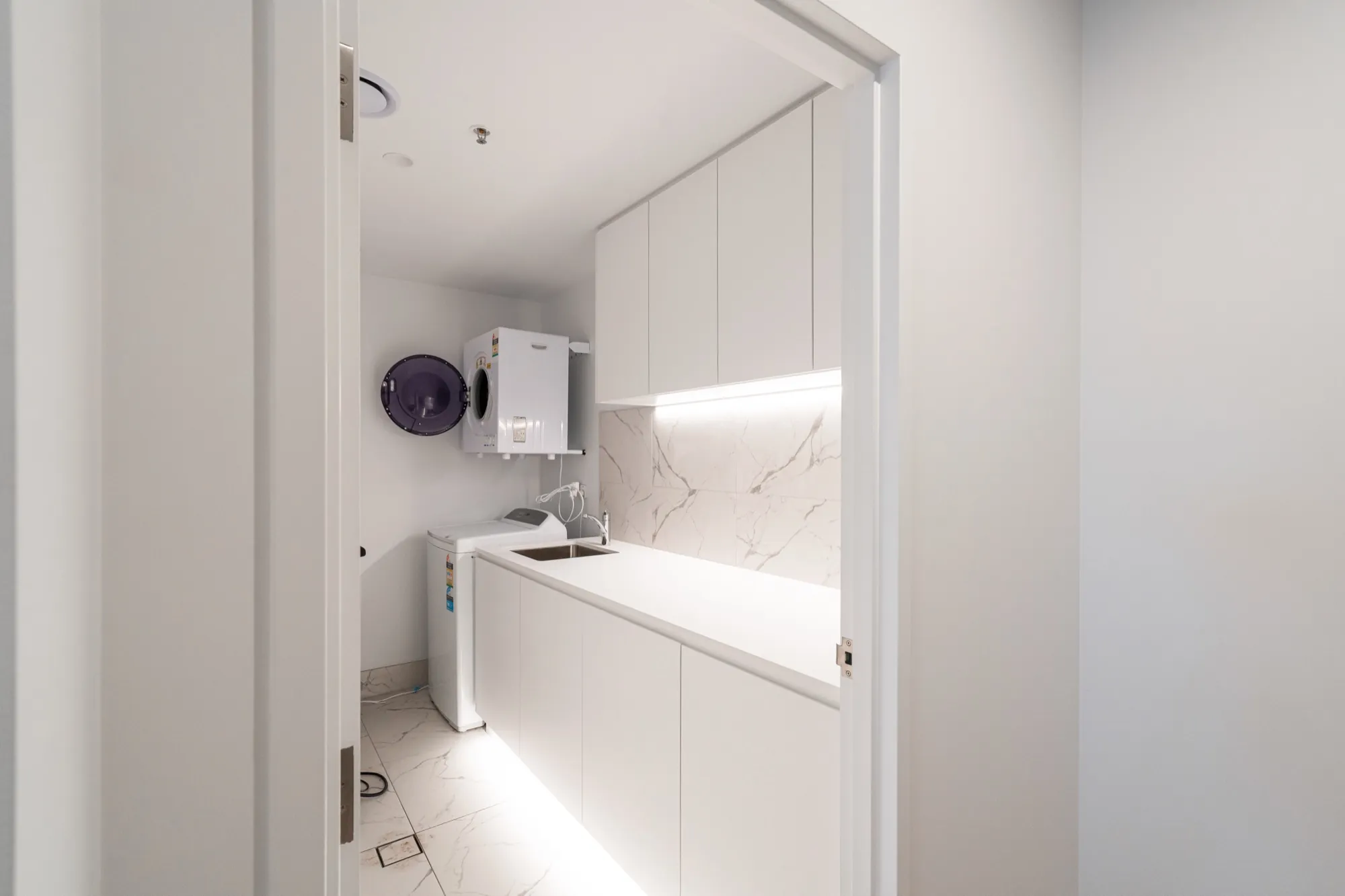 Laundry in the second Phillip apartment with LED strip lighting under the cabinets
