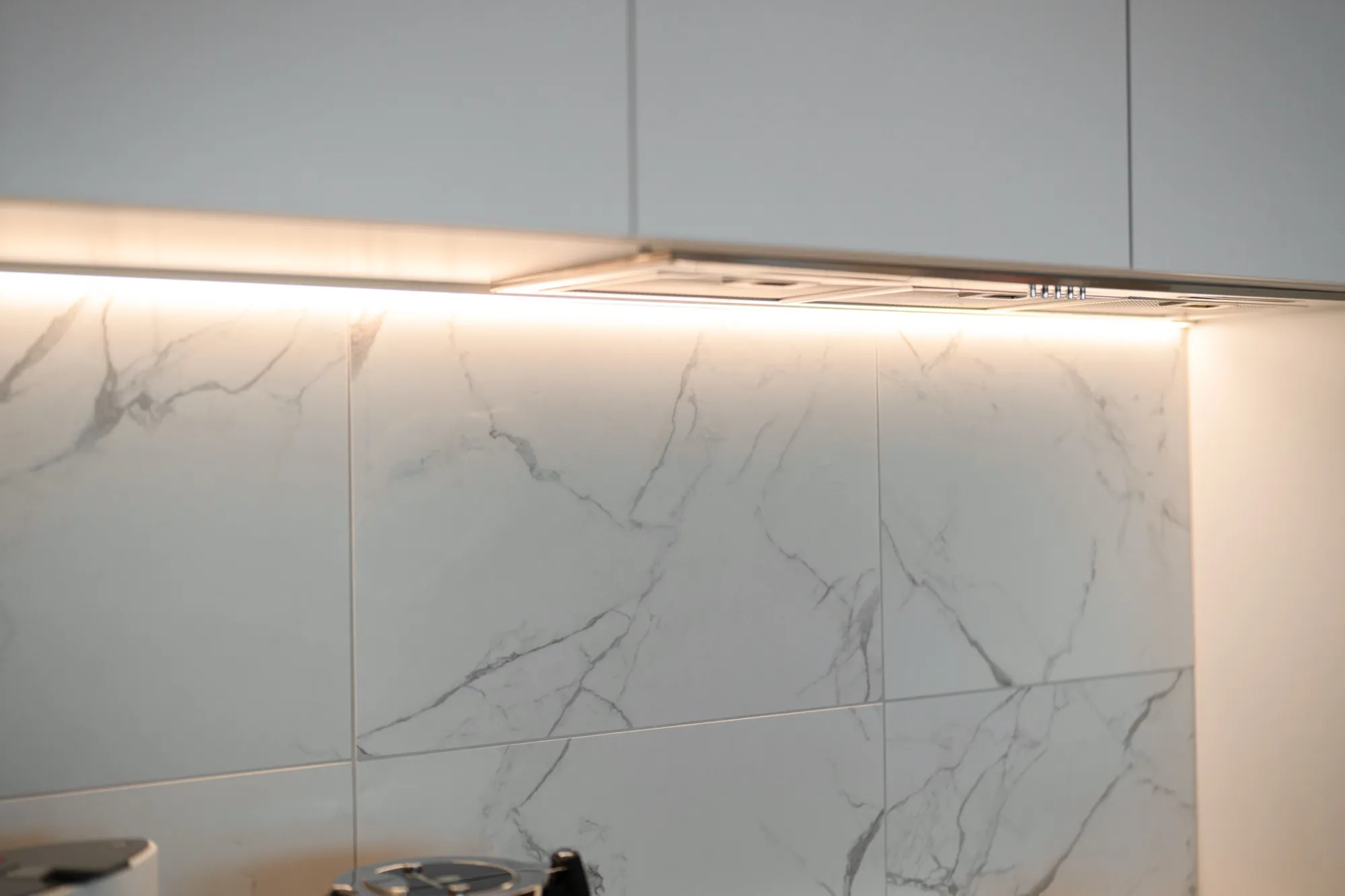 Under-cabinet LED strip and integrated rangehood detail in the second Phillip apartment